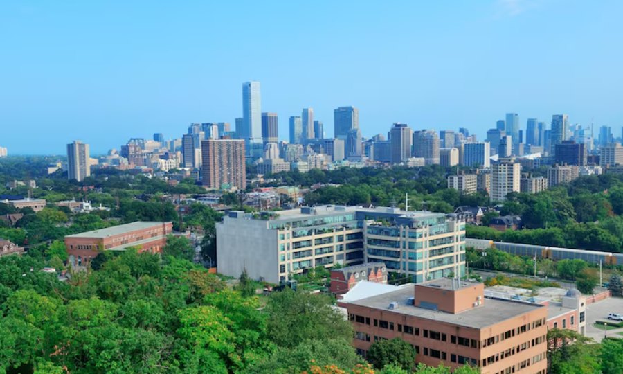 Greensboro, NC skyline with city buildings and green trees