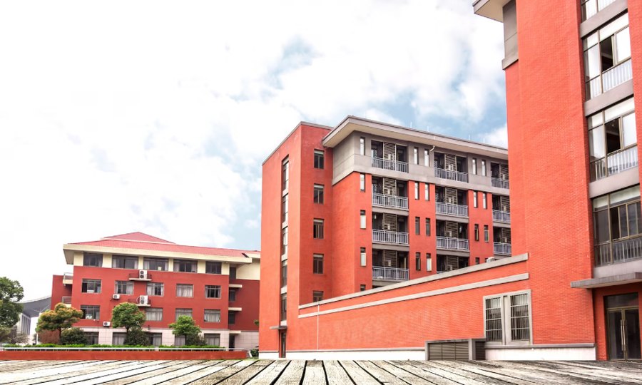 Red brick school buildings under a cloudy sky